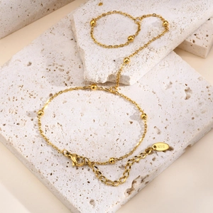 Detail of 18K gold-plated double-layer chain bracelet with beads and K18 hallmark tag