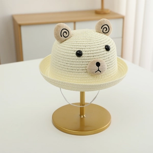 Détail d'un chapeau de paille pour enfant avec oreilles d'ours et broderie d'animaux