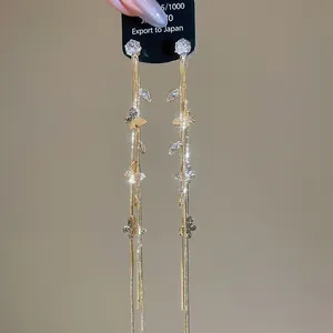 Vue macro de boucles d'oreilles papillon dorées avec pompons en zircon brillant
