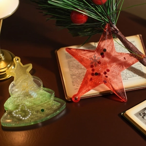 Close-up of festive star and tree resin pendants with glitter and snowflake sequins