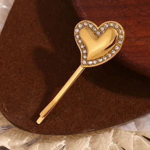 Detailed view of 18K gold plated heart hair clip with rhinestone border on felt
