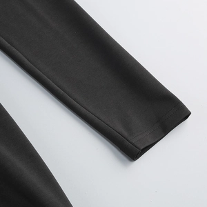 Detail of high-density black knit dress sleeve with precision double-needle flat stitching
