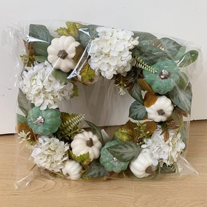 Fall wreath detail showing white hydrangeas and mini pumpkins in protective packaging