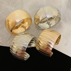 Modern wide geometric metal bracelets in gold and silver with hammered and brushed textures