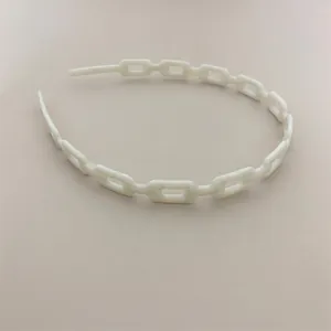 Close-up of a white acetate headband featuring a hollow chain-link design and matte finish