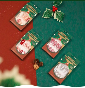Detailed view of Christmas press-on nails featuring red glitter and snowflake designs
