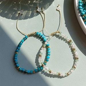 Detail of handmade beaded bracelets with turquoise stones, gold beads and star charms