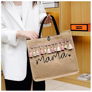 Detail shot of jute tote bag featuring Mama heart print and colorful tassel decoration