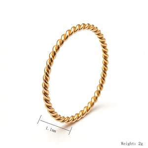 Detail shot of 1.1mm golden twisted rope ring showing 2g weight and metal texture