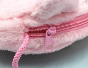 Détail de la texture en peluche rose et de la fermeture éclair métallique du sac licorne