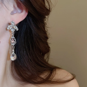 Detail of silver drop tassel earrings with sparkling pink and clear crystals on model