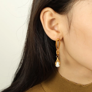 Elegant gold chain earrings with white pearls shown on a model for a stylish look