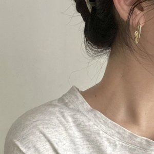 Minimalist gold U-shaped sterling silver hoop earrings worn for a modern stylish look