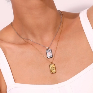Layered gold and silver tarot necklaces with Sun and World pendants on a model