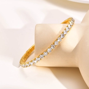 Detail of adjustable gold tennis bracelet with shimmering cubic zirconia stones on stand