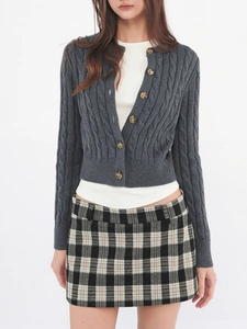 Detail of dark grey cable knit cardigan with amber buttons and classic V-neckline texture