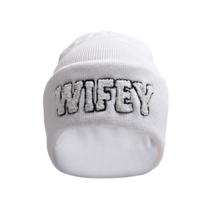 Detailed close-up of the WIFEY embroidered patch on a white knit beanie hat