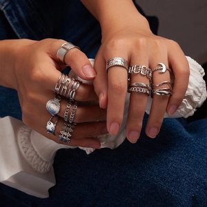 Vintage multi-layer stainless steel ring set with crown and moon designs on denim background