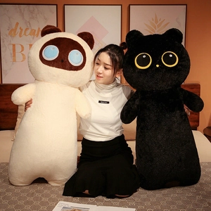 Detail showing a model holding long cat plush pillows in black and cream colors
