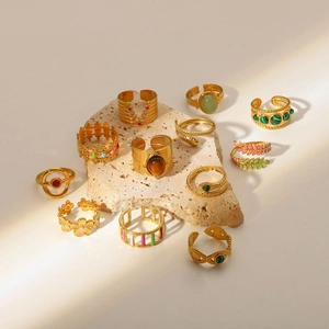 Disposizione dettagliata di anelli vintage in oro 18k con pietre naturali e smalto