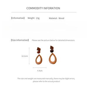 Detail view of geometric wooden teardrop earrings with dimensions and 23g weight info