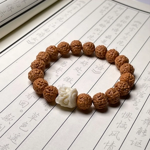 Macro shot of Nepal Rudraksha beads with a white beast carving on Chinese calligraphy