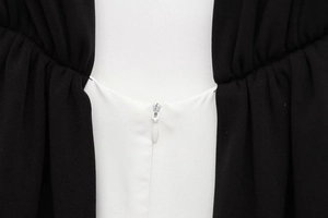 Detailed macro view of invisible white zipper on black and white patchwork dress fabric