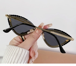 Detail of cat eye sunglasses with gold frames and black crystal bead embellishments