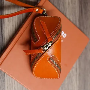 Handcrafted orange vegetable-tanned leather zipper key case with wrist strap