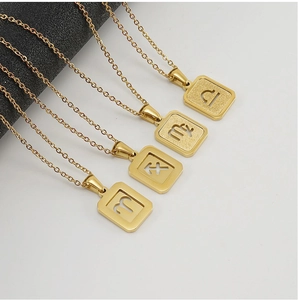 Détail de quatre colliers avec pendentifs zodiaque carrés en acier doré à l'or 18 carats