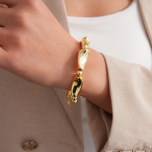 Detailed view of irregular organic lava design gold bracelet with delicate bead accents