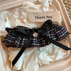 Detail of checkered acrylic hair claw with black ribbon and crystal in a gift box