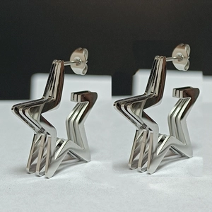 Detailed view of silver triple-layered pentagram stud earrings in polished stainless steel