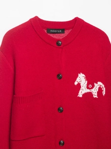 Dettaglio del cardigan in maglia rossa con motivo a cavallo bianco e bottoni neri