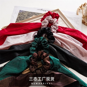 Close-up of elegant velvet and satin bow scrunchies with long ribbons in multiple colors