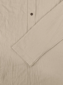 Close-up of khaki linen shirt featuring textured fabric and a dark brown button detail