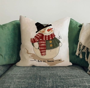 Detail des Weihnachts-Kissenbezugs mit Schneemann und Text LET IT SNOW auf dem Sofa