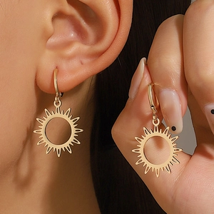 Détail de boucles d'oreilles soleil doré montrant la taille sur le mannequin