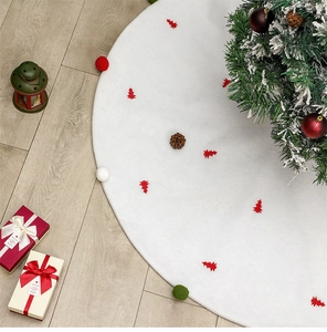 Vue détaillée du tapis de sapin blanc avec sapins rouges et pompons sur sol en bois