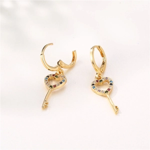 Golden heart key earrings with colorful cubic zirconia stones on white background