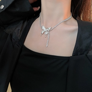 Macro detail of silver butterfly fringe necklace with sparkling crystals on black apparel