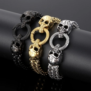 Detail of punk skull bracelets in gold black and silver finishes on a black display stand