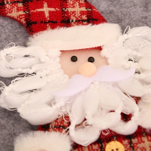 Macro detail of handmade 3D Santa Claus plush with red plaid hat and curly yarn beard