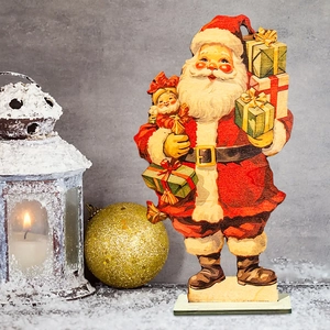 Vintage wooden Santa Claus tabletop decoration with gift boxes on snow base