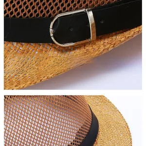 Close-up of the mesh straw sun hat with black faux leather strap and metal buckle