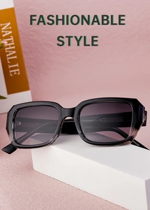 Detail of square black sunglasses with gradient lenses on a minimalist pedestal