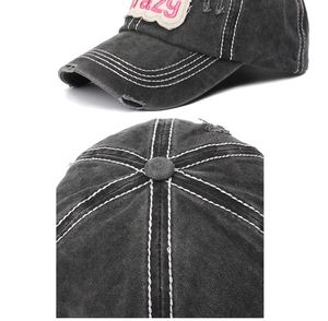 Detail of distressed dark grey baseball cap with pink Crazy embroidery and worn edges