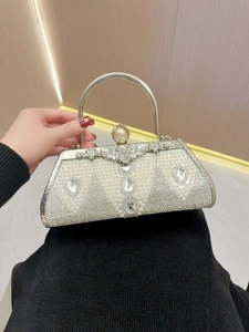 Detail showing elegant evening clutch with pearls, crystals, and silver metal handle