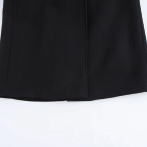 Detailed close-up of smooth hemline and texture on black wool-like long coat