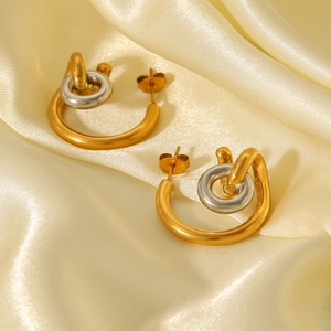 Interlocked two-tone gold and silver stainless steel C-shape earrings on silk fabric